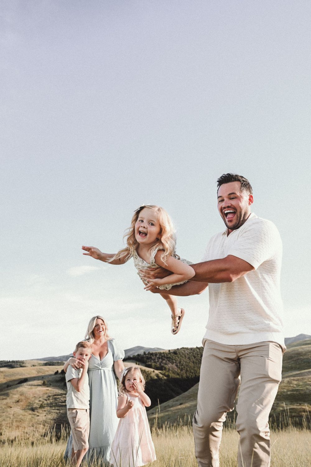 Playful moment captured in a golden field during sunset.