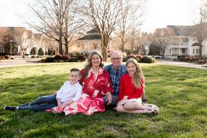 Family relaxing together on sunny green grass during springtime.