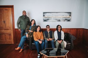 Interior photo of family relaxing on floor against white walls with modern decor.