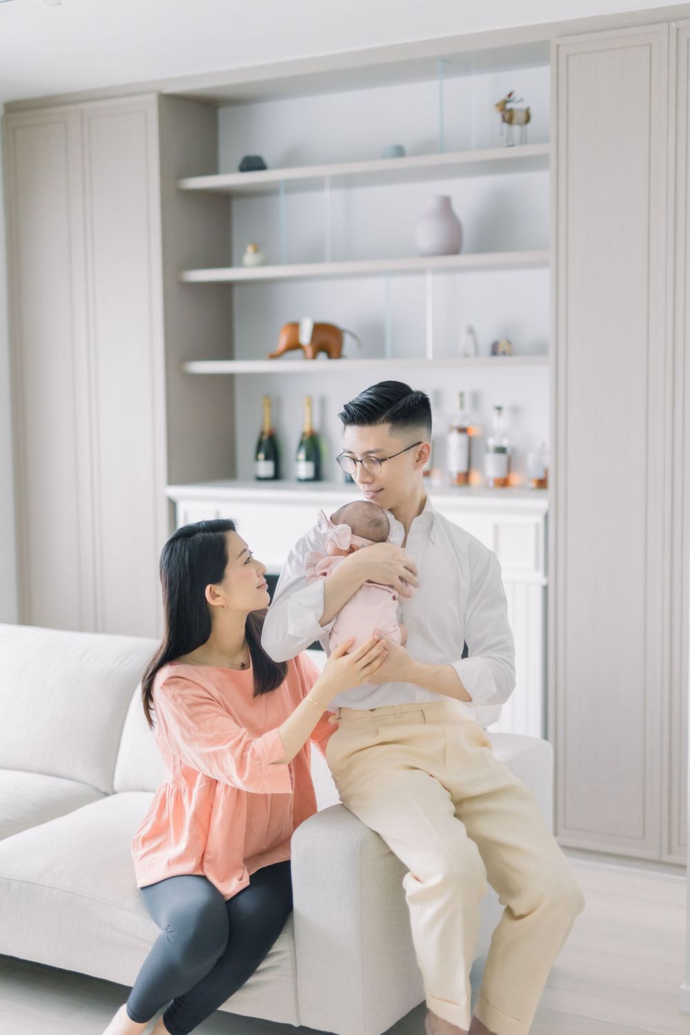 Family sharing tender moments together in a bright modern living room with white built-in shelving.