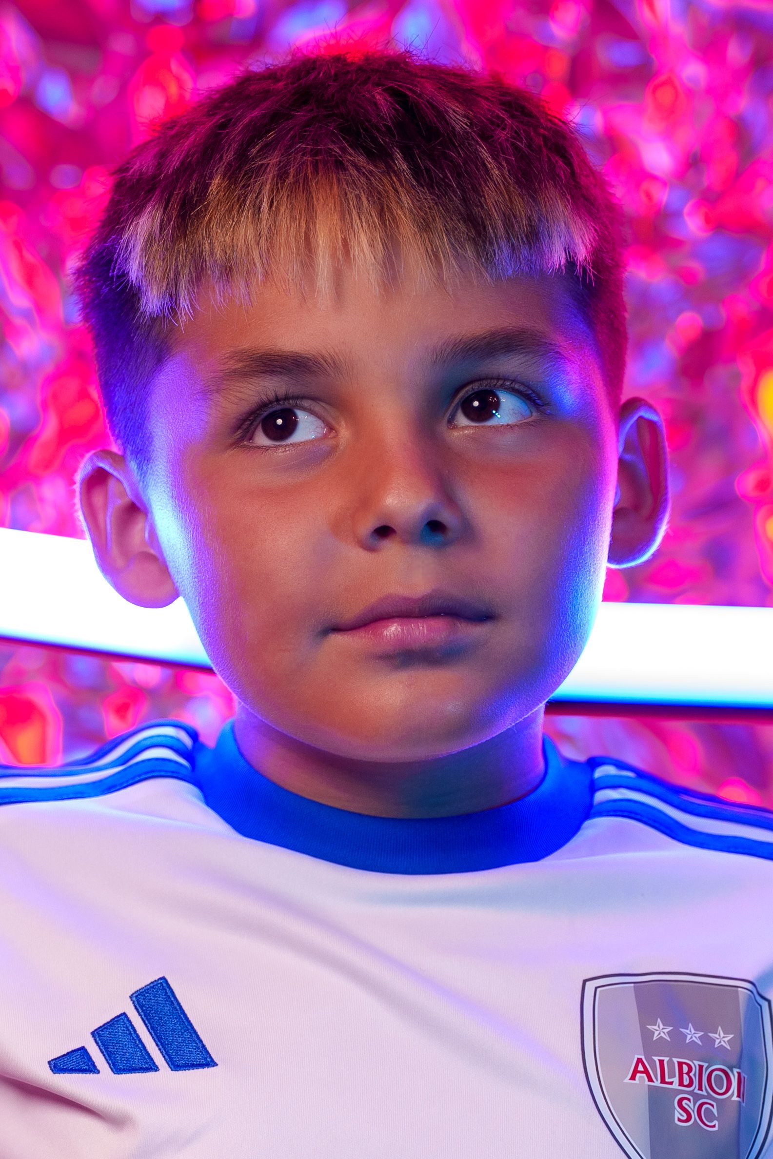 Close up of Albion soccer jersey with dramatic pink lighting effects.