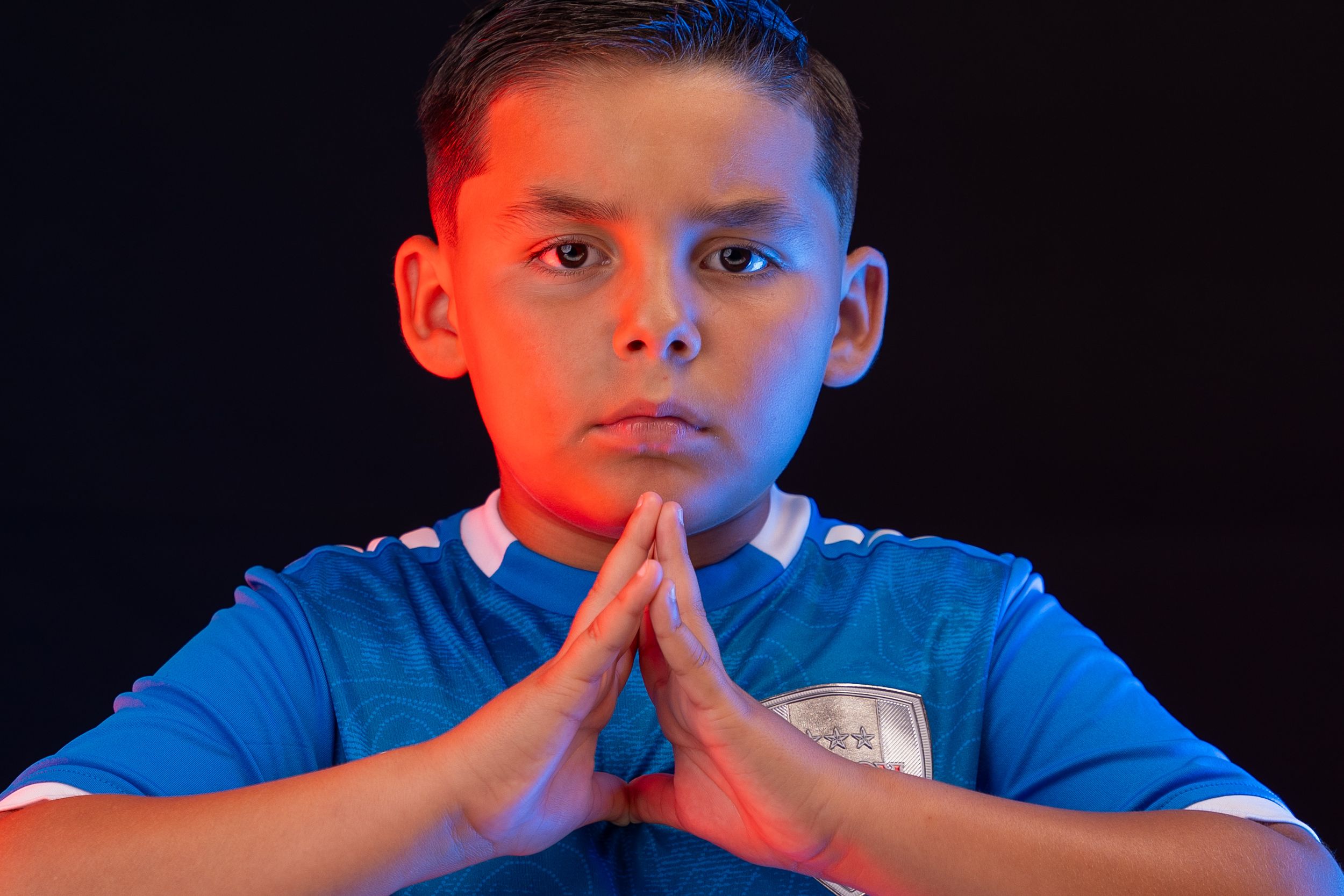 Young sports fan in blue Albion jersey dramatically poses against dark background with expressive faces.