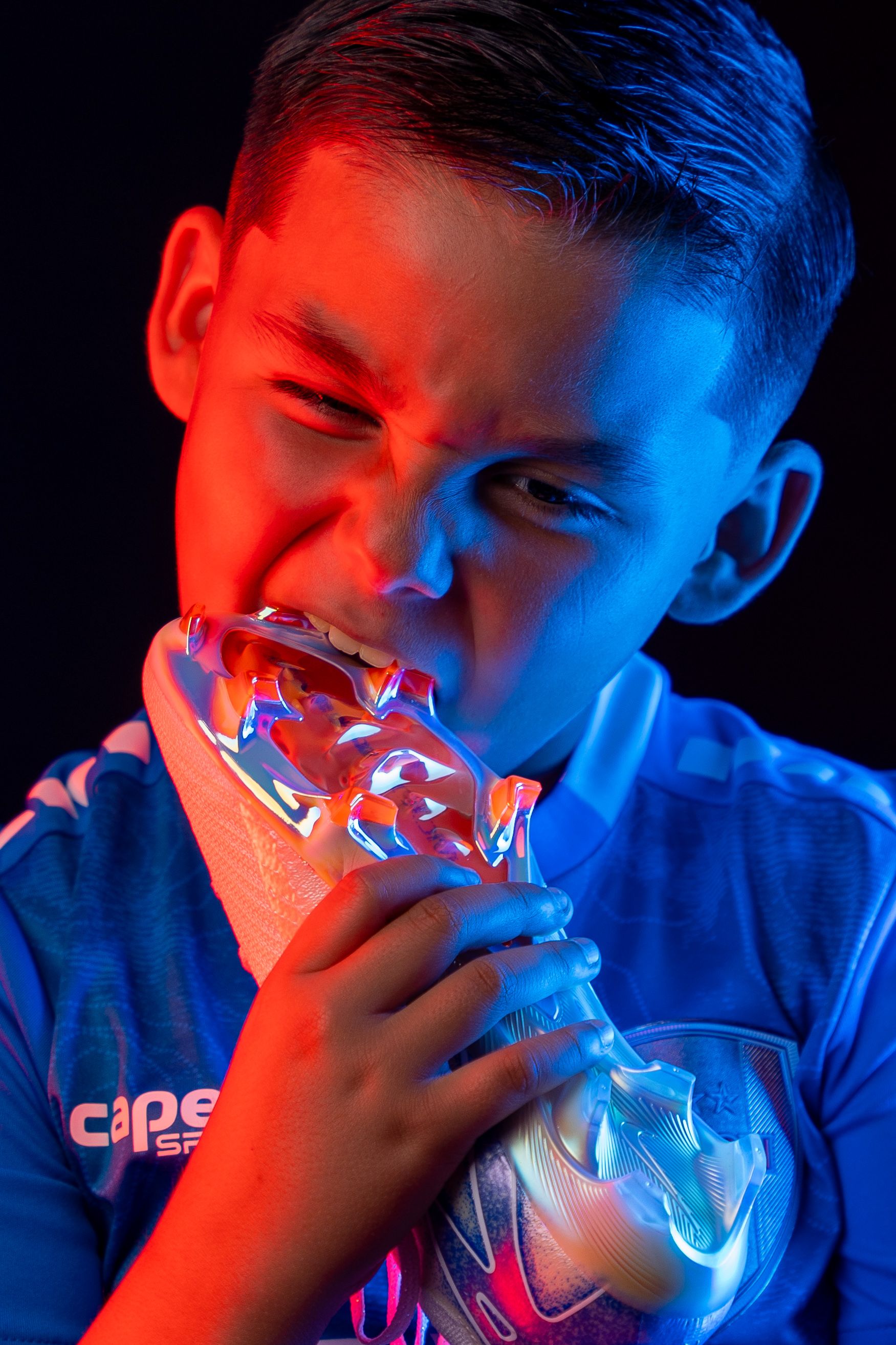 Dramatic portrait with red and blue lighting effects showing translucent object.