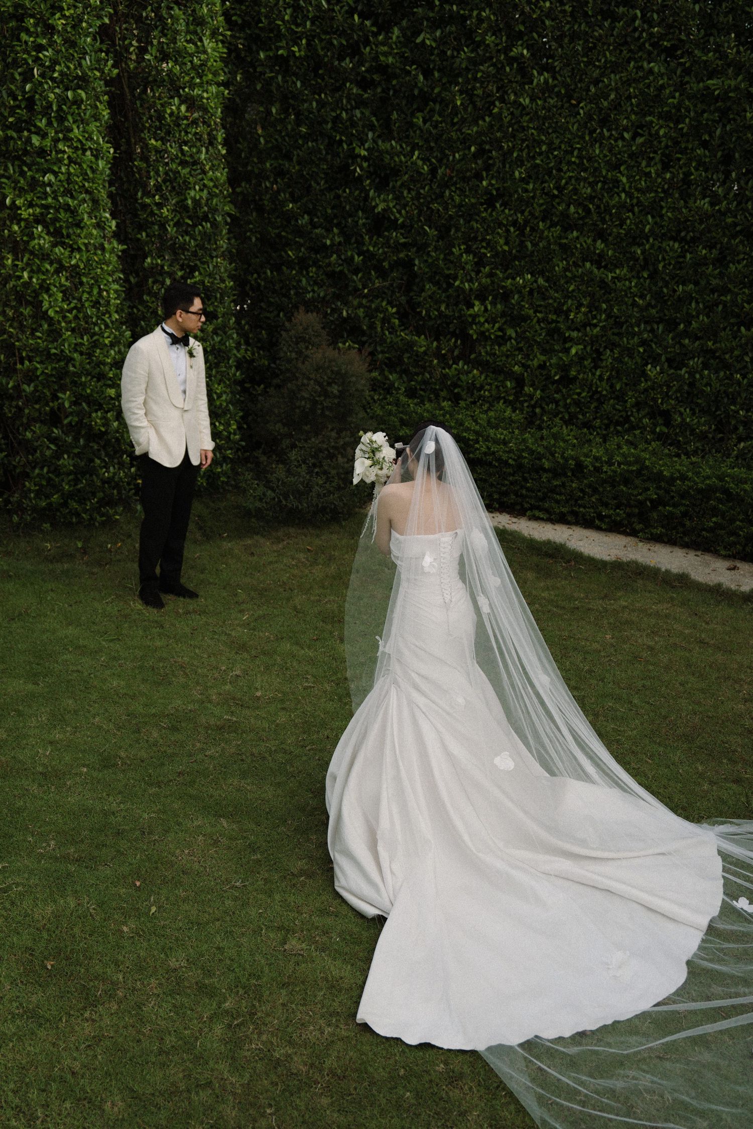 Wedding dress with long flowing train and veil captured in garden setting from different angles.