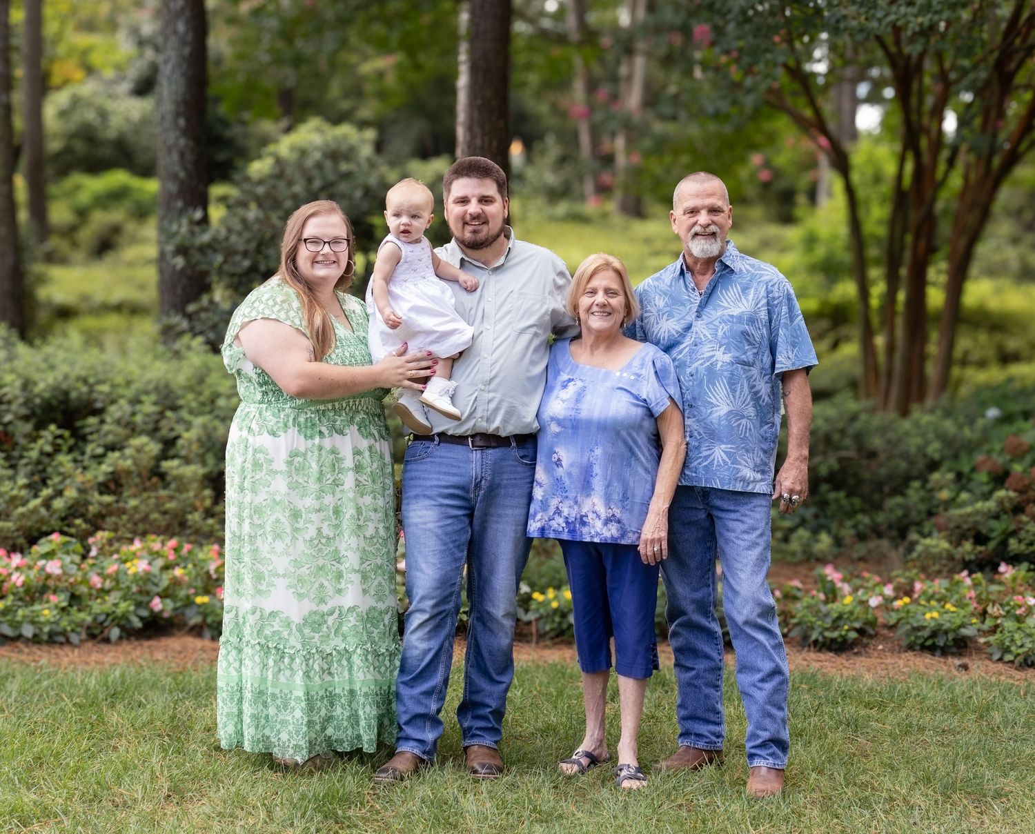 Extended family posing together for photos in a wooded outdoor setting.