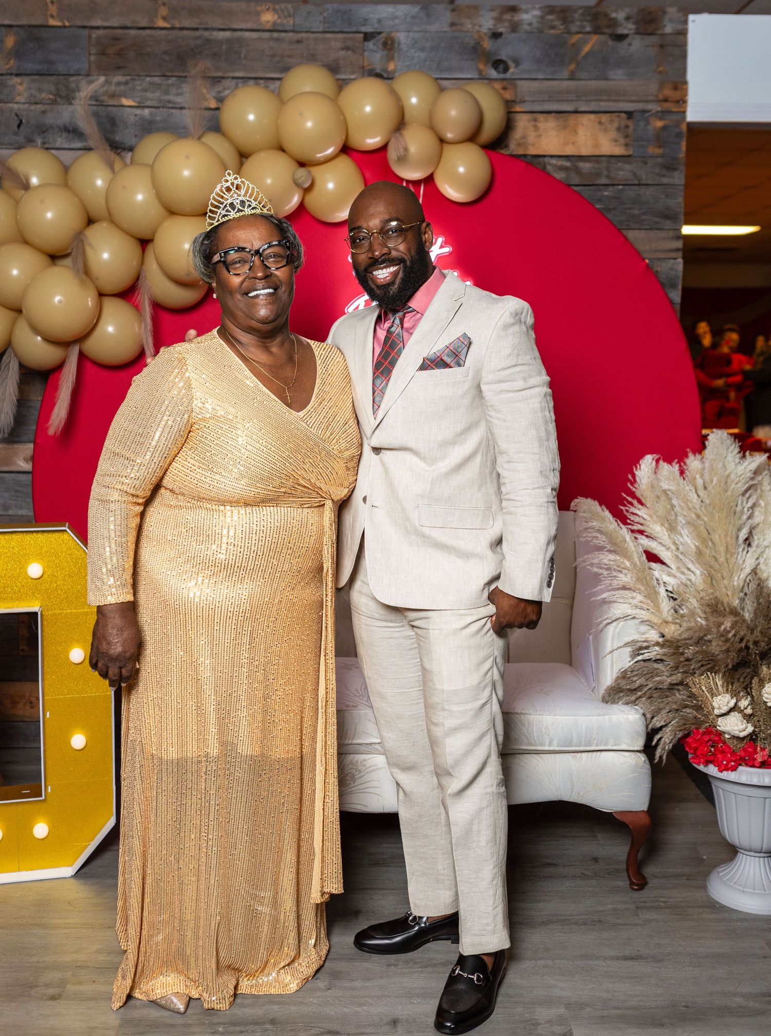Formal event photos with gold and white decor featuring elegant attire against a rustic wood wall.