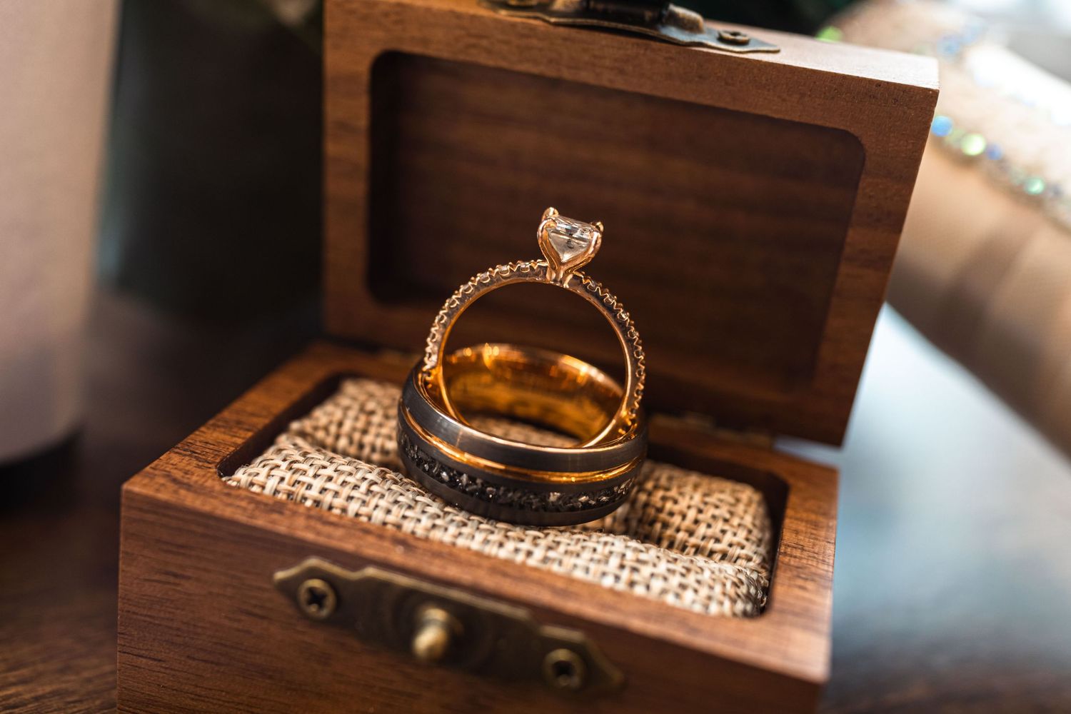 Wedding rings displayed on wooden surfaces with rustic textures.