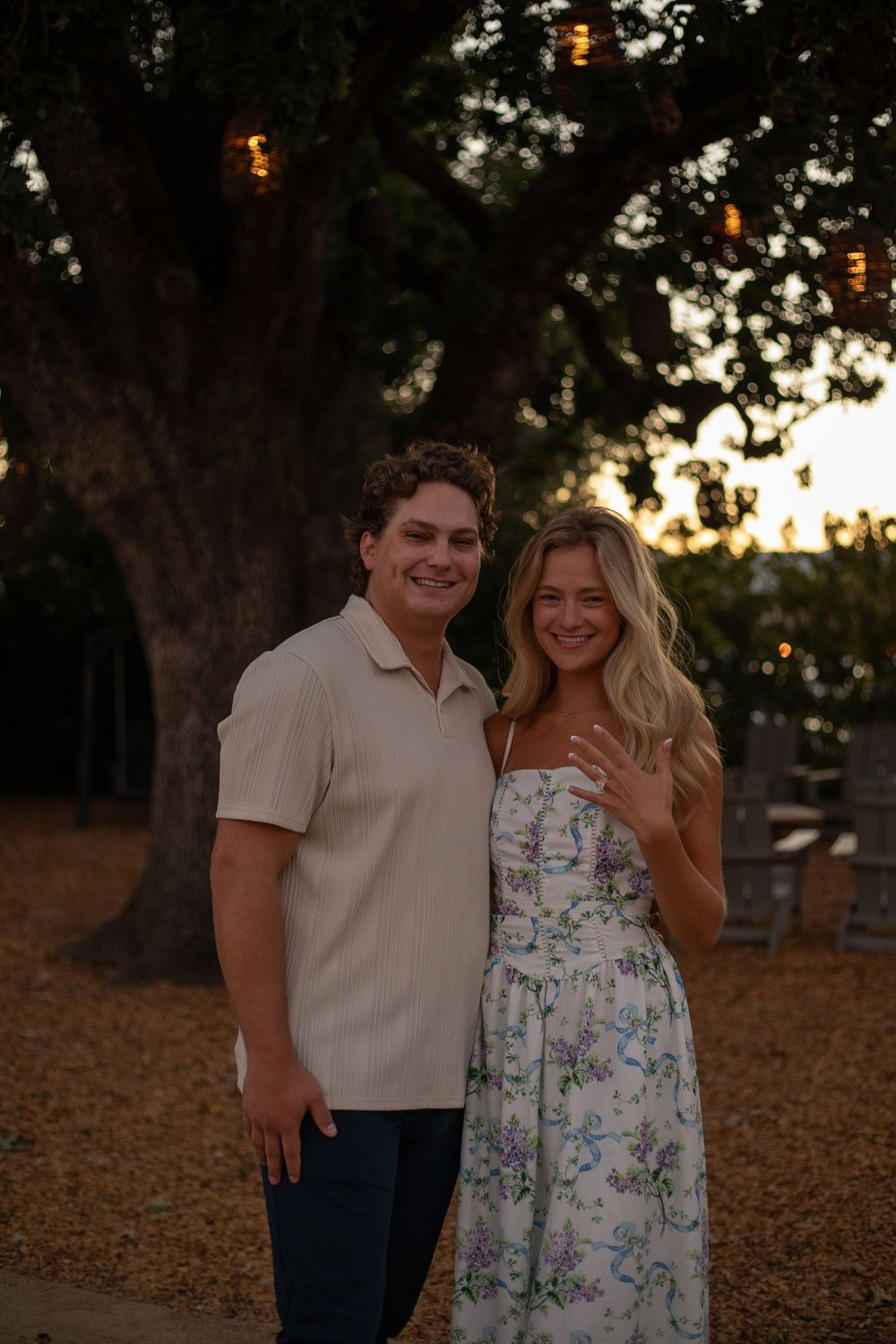 Two people share a joyful moment together outdoors at dusk.