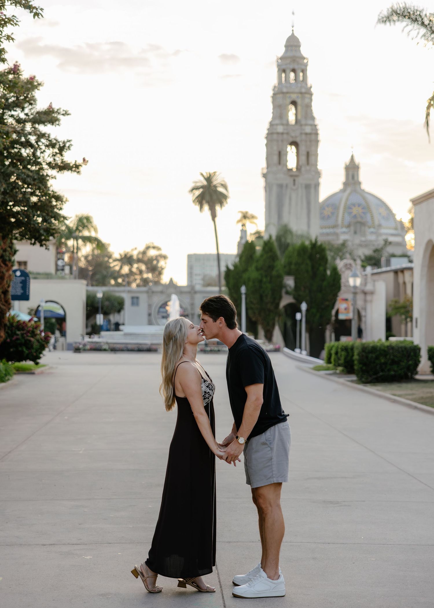 A couple poses in various stances with a beautiful Spanish colonial church in the background.