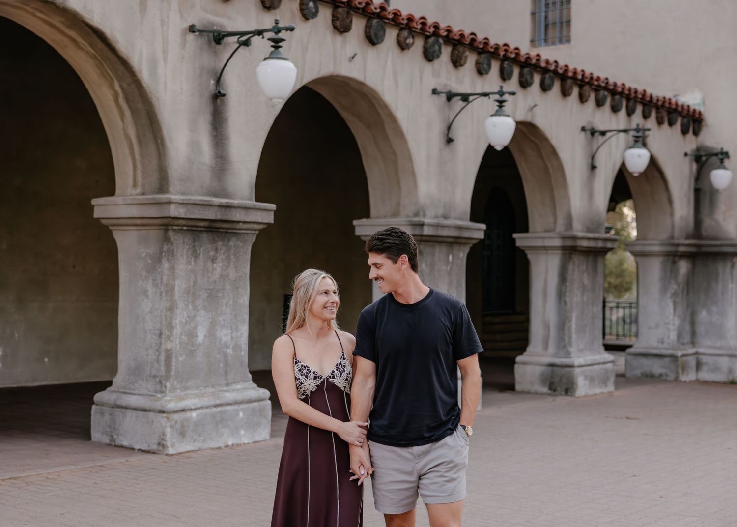 Historic archway colonnade with stone columns and Spanish colonial architecture.