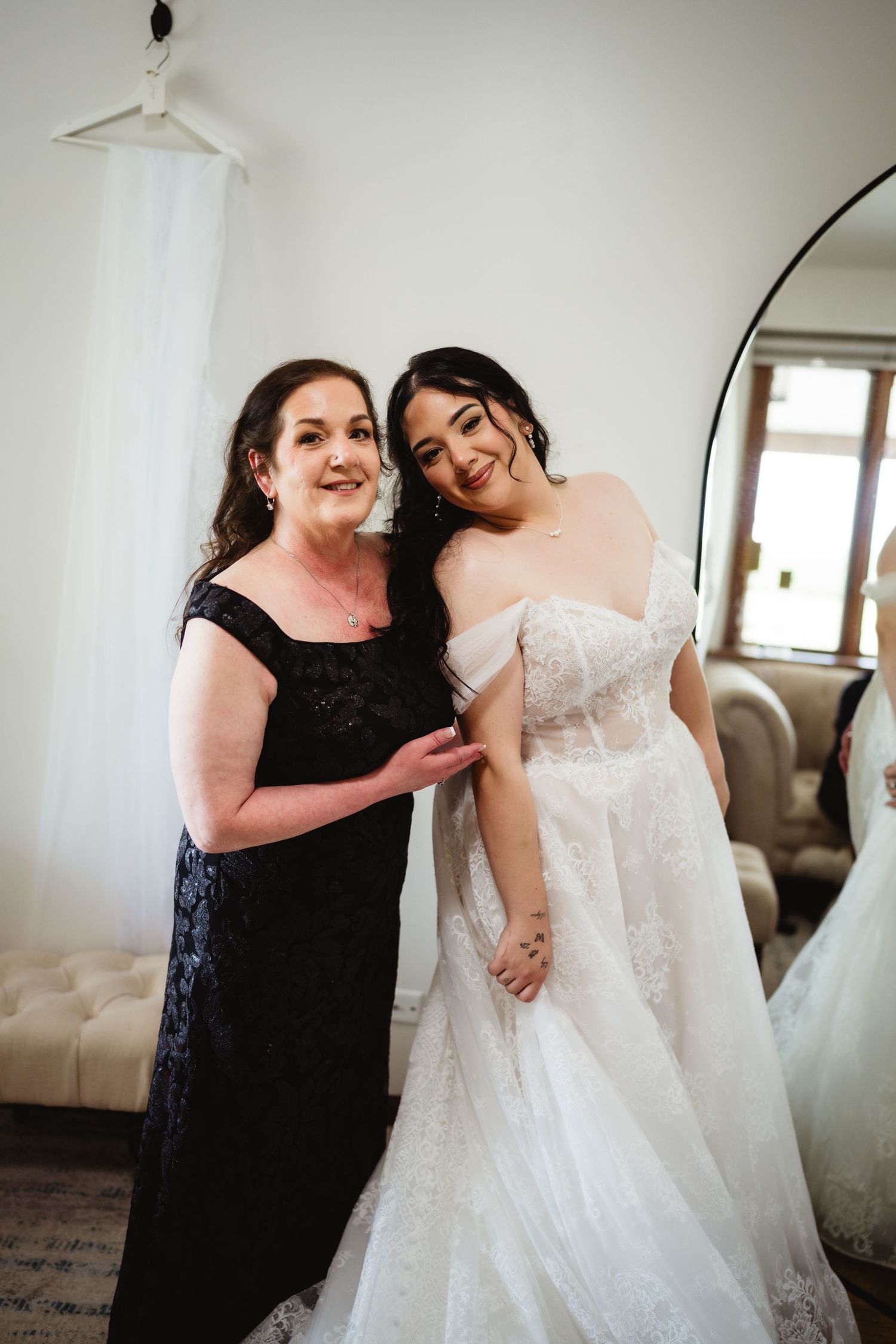 Two people sharing a joyful moment together during a wedding, with one wearing a black gown and one in a white bridal gown.