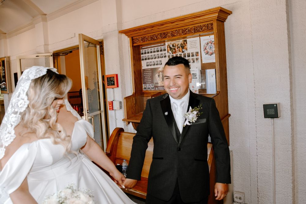 A bride and groom share a special moment in the hallway on their wedding day.