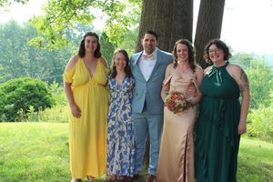 Married couple poses with friends during wedding photo session.