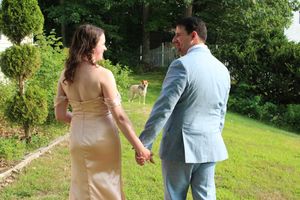 Candid photo of married couple with their pet dog during wedding photo session.
