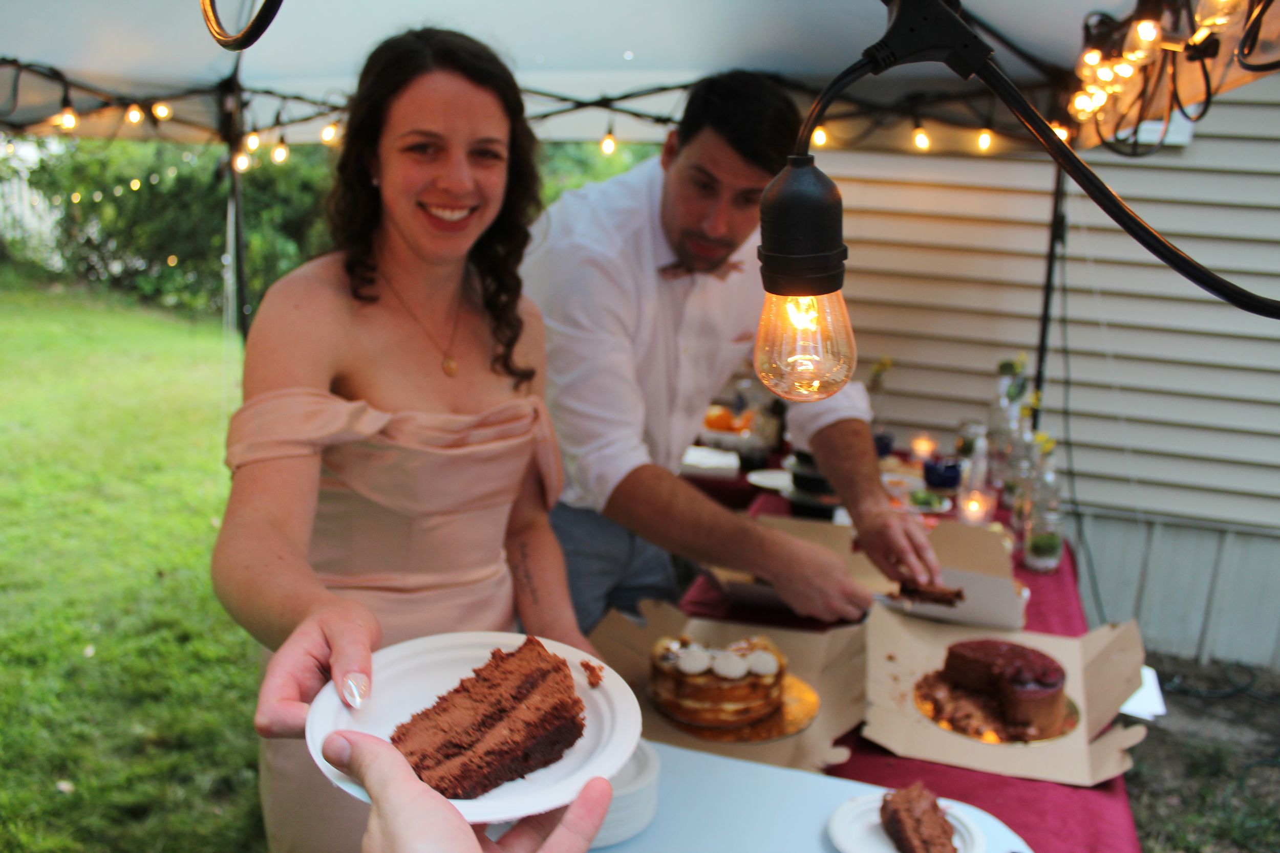 Candid photo of married couple serving cake during wedding photo session.