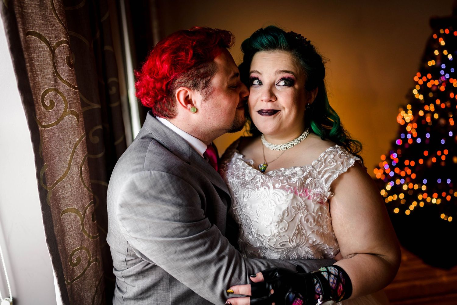 Warm-toned wedding portraits with Christmas lights creating a romantic holiday atmosphere.