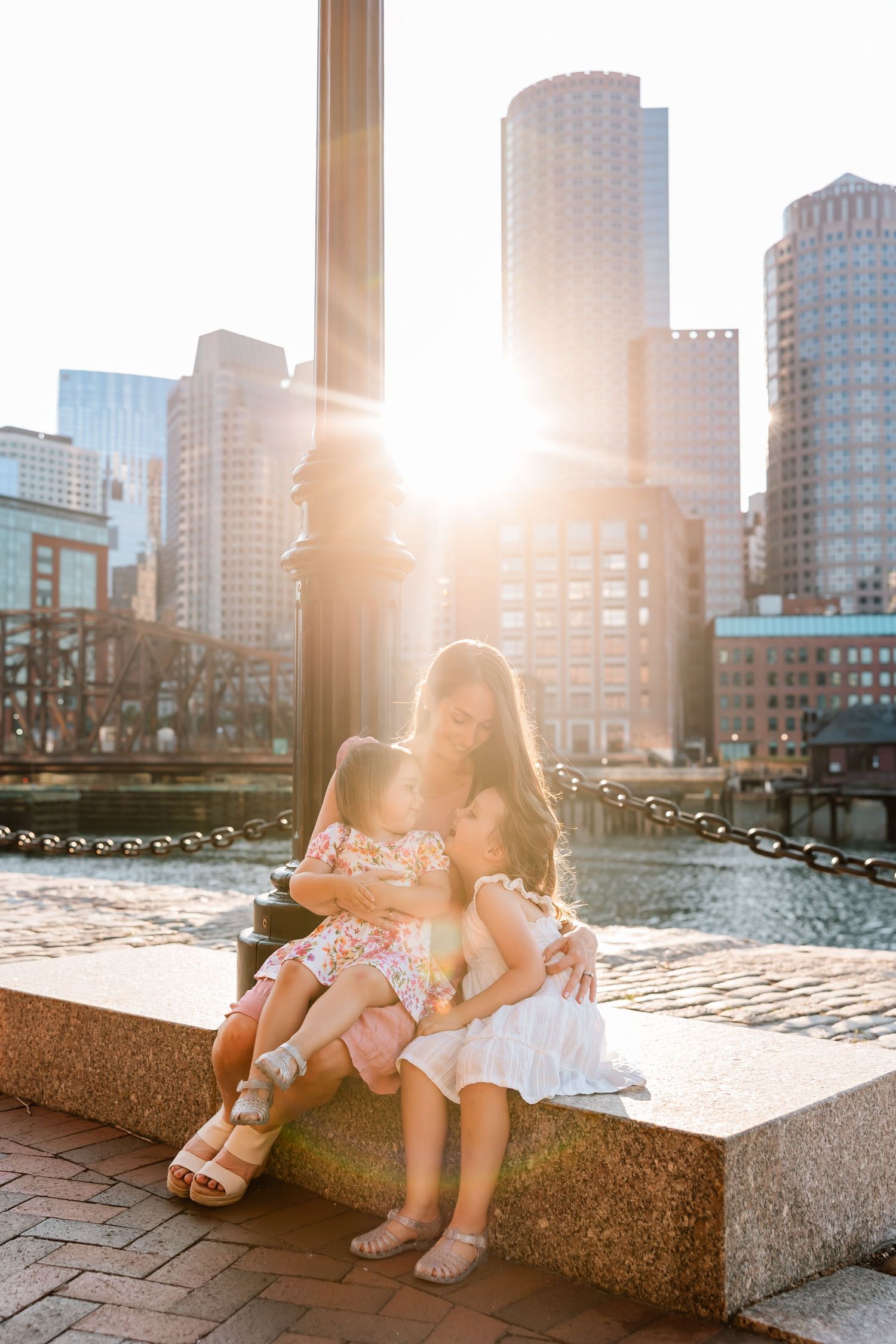 A sequence of sunlit urban waterfront images showing feet resting on stone ledges with city buildings in the background.