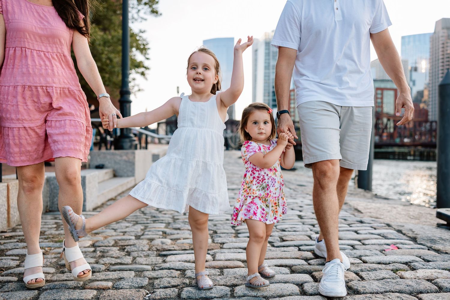 Two people in summer outfits walking together on cobblestone streets showing their footwear step by step.