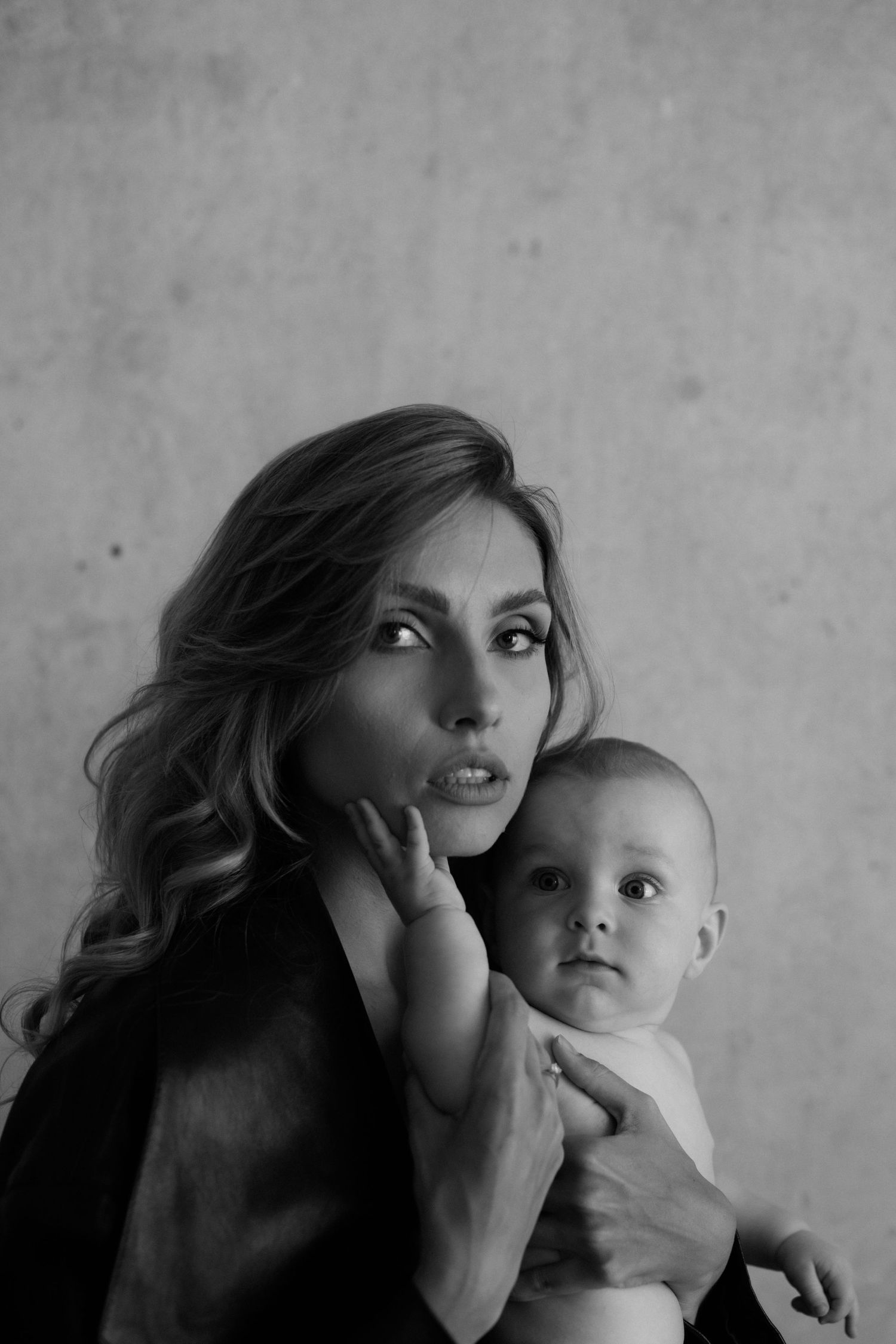 A black and white sequence showing affectionate playful moments between a parent and baby.