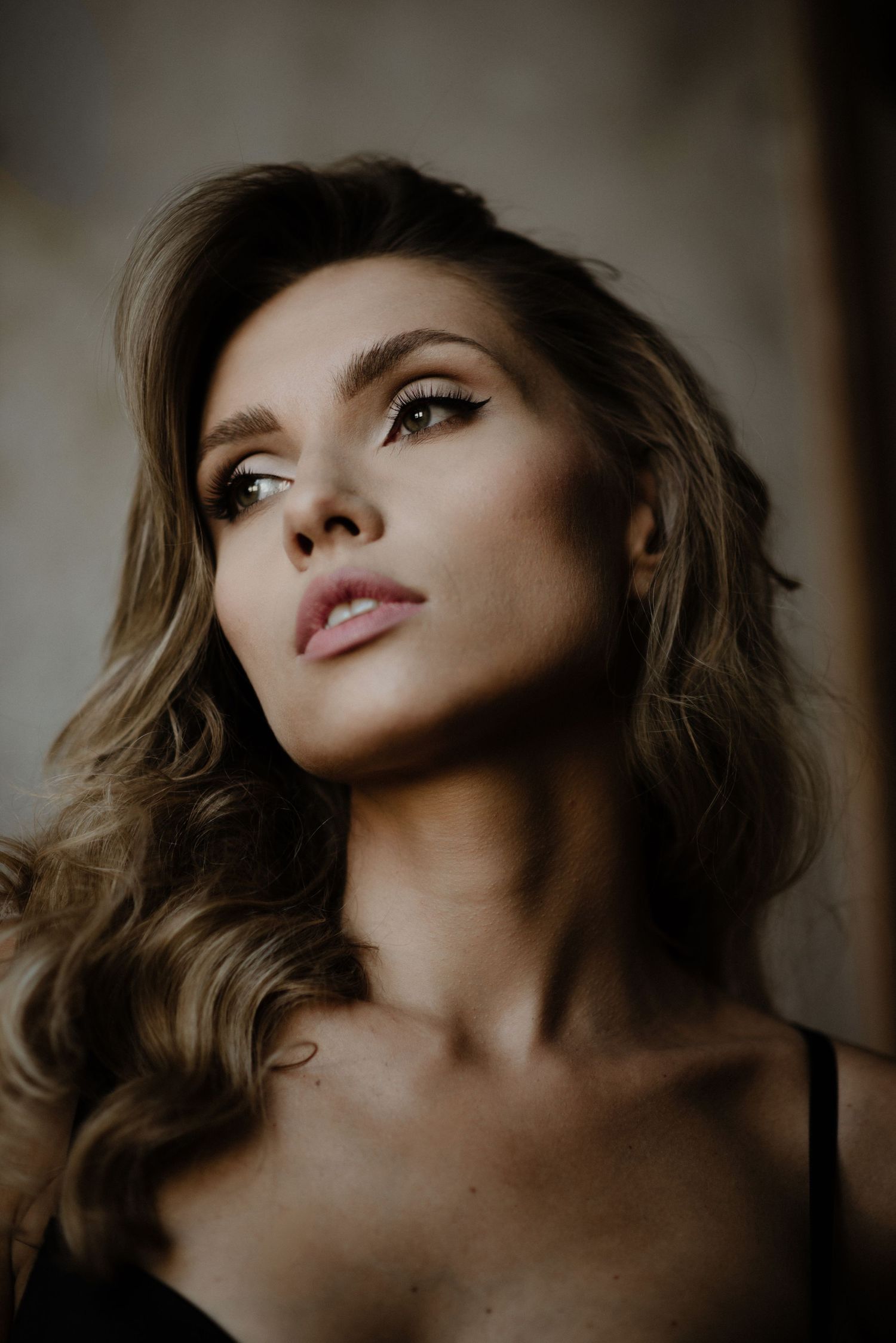 Dramatic close-up sequence of woman with tousled hair and natural makeup in moody lighting.