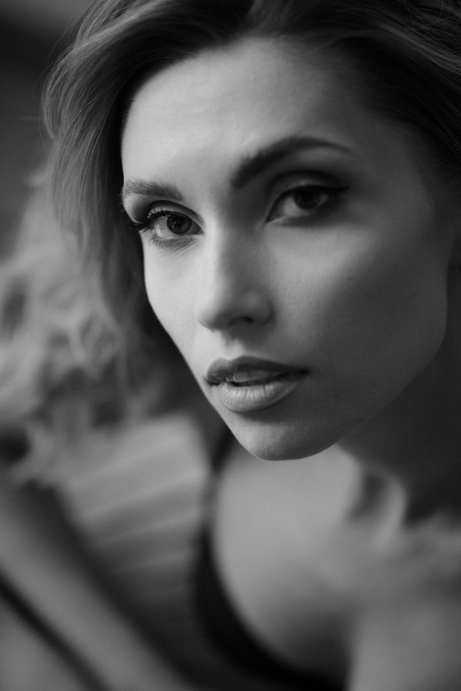 Black and white artistic portraits showing stylized close-up views of facial features with dramatic lighting and shadows.