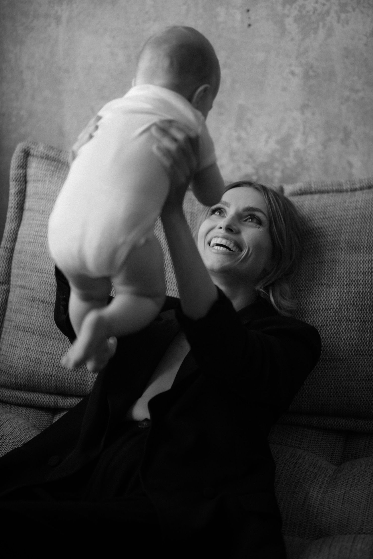 A sequence of black and white photos showing a playful interaction on a couch, capturing moments of joy and movement.