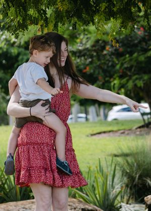 Family playing and walking together in sunny garden setting.