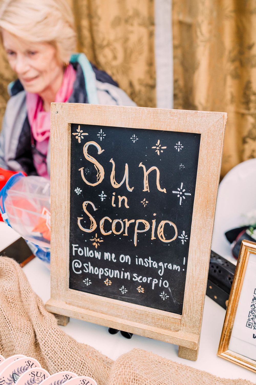 Small chalkboard signs with astrological themes and hand-drawn stars displaying 'Sun in Scorpio' and Instagram details.