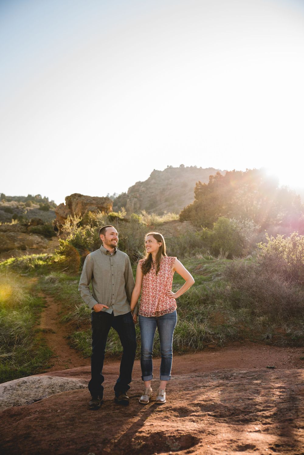 A couple walks together on a desert trail during golden hour at Garden of the Gods in Arizona.