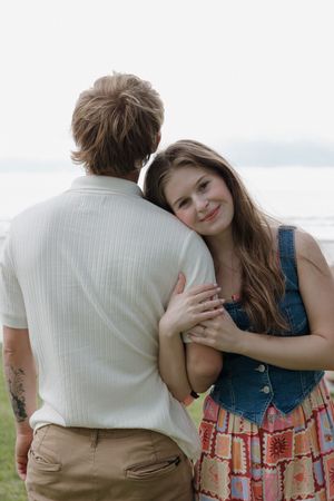 Couple sharing tender moments while sitting outdoors.