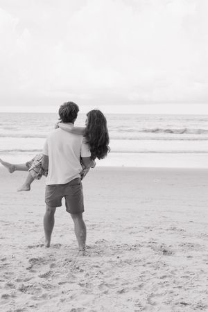 Black and white photos showing a romantic dance sequence on a beach with crashing waves.