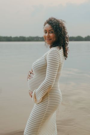 Series of photos showing joyful moments between couple in coordinated white outfits by waterfront setting.