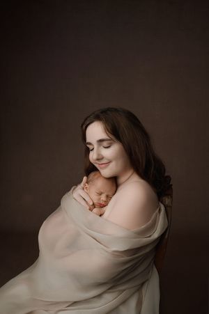 A series of soft, moody portraits in warm brown tones showing someone wrapped in delicate cream-colored fabric.