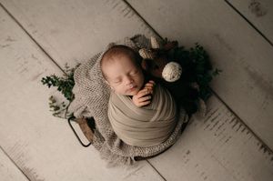 Soft focus artistic portrait photography featuring gentle neutral tones with a wood floor background.