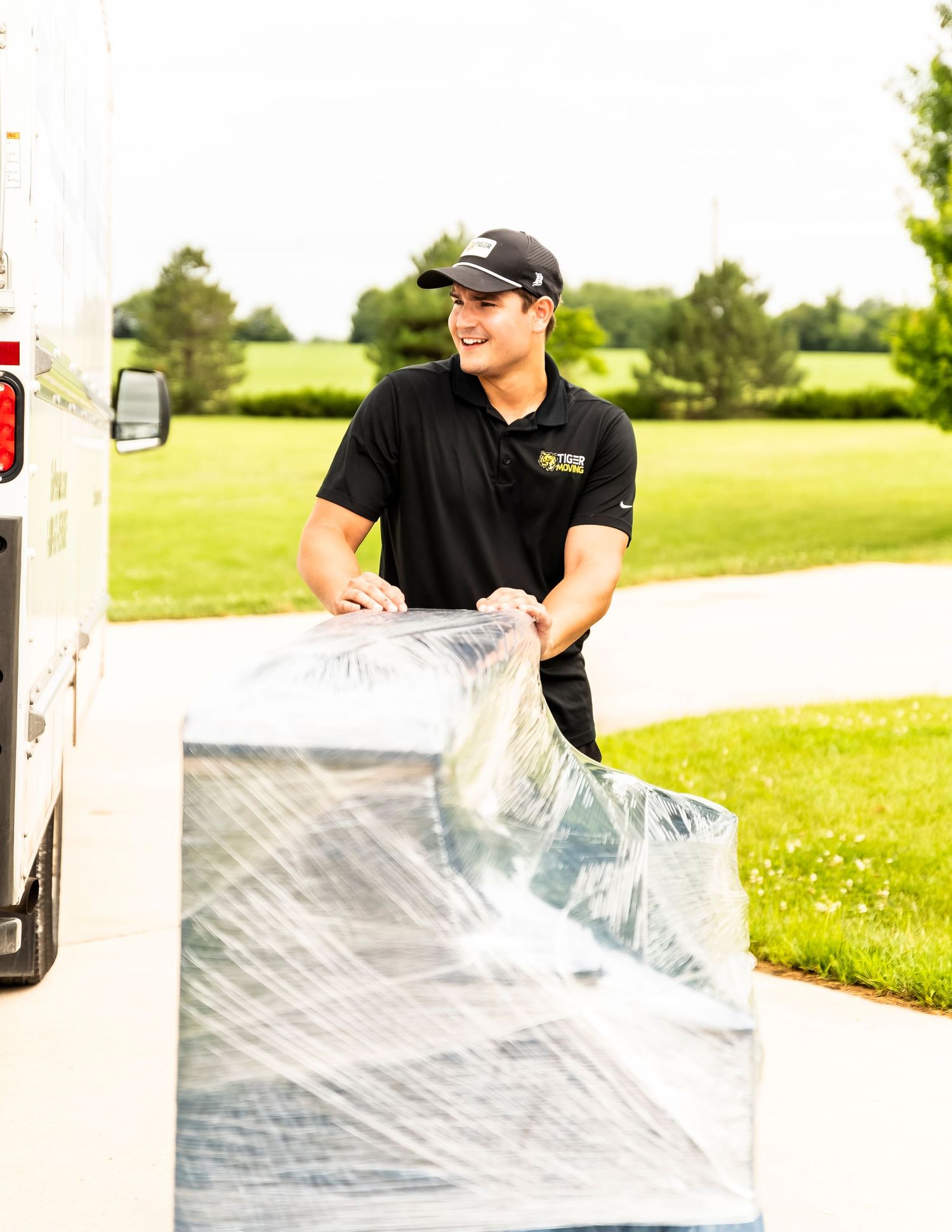 Person installing clear plastic sheeting or protective covering outdoors.