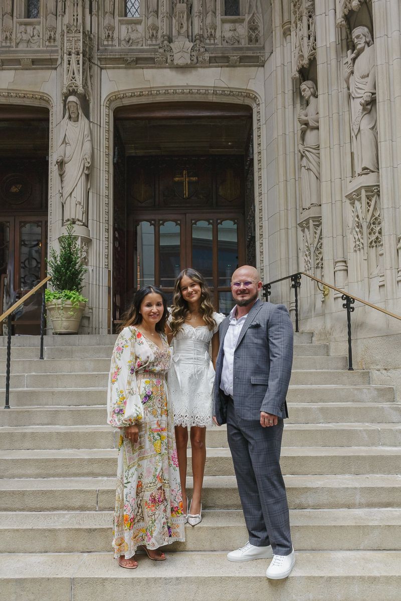 Mom, dad, and baptism girl portrait at St. Thomas Church entrance by Paula Brearley