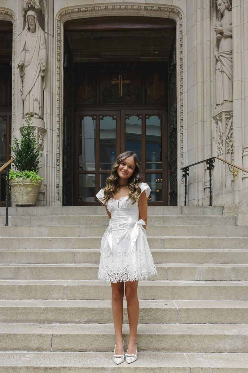 Baptism girl posing on stairs at St. Thomas Church NYC, photographed by Paula Brearley