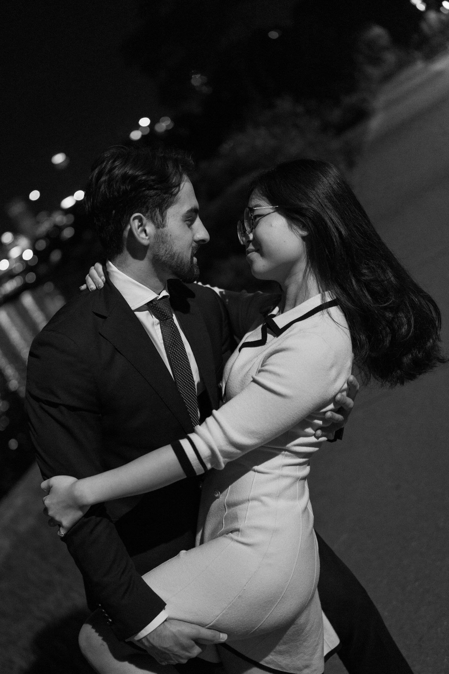 A couple in formal attire share an intimate dance sequence captured in black and white photography.