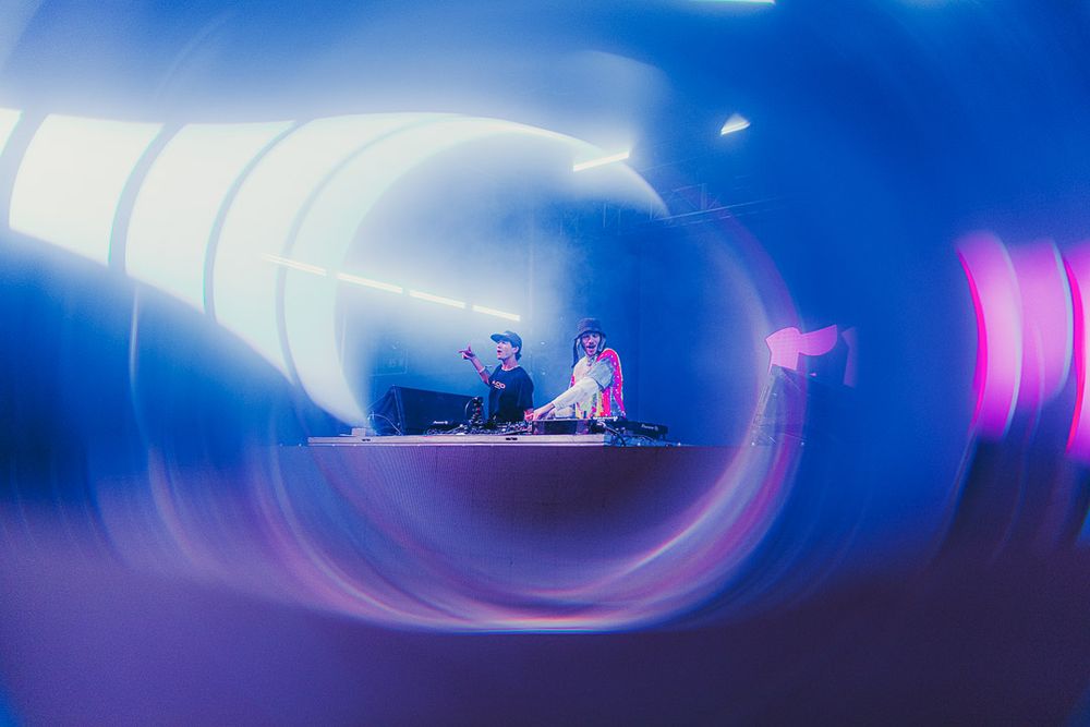 Concert stage viewed through a spiral light effect creating a purple and blue vortex pattern.