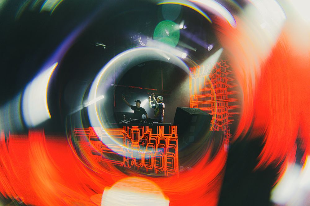 Distorted architectural elements in an orange-tinted circular tunnel effect with geometric shapes.