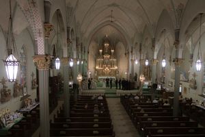 Wedding guests seated in wooden church pews during a ceremony.