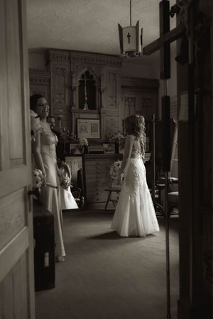 Black and white wedding photos showing a bride in a white gown posing in an elegant indoor setting.
