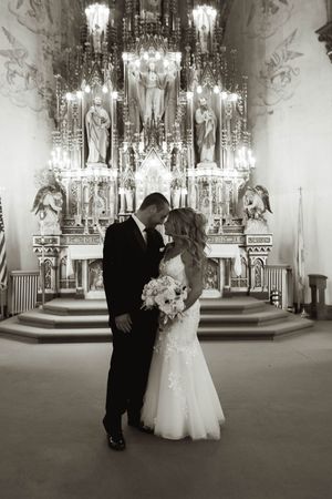 Black and white photos of a wedding ceremony in an elegant church with chandeliers.