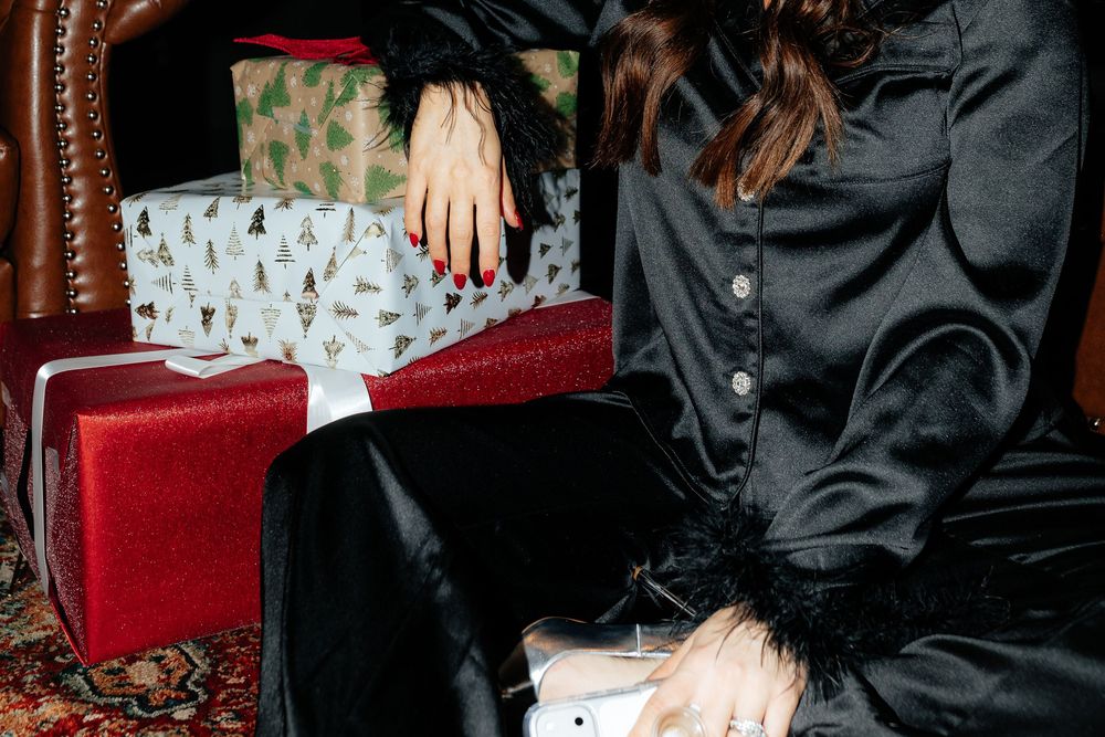 A group of people in formal attire sit on red velvet furniture during an elegant event.