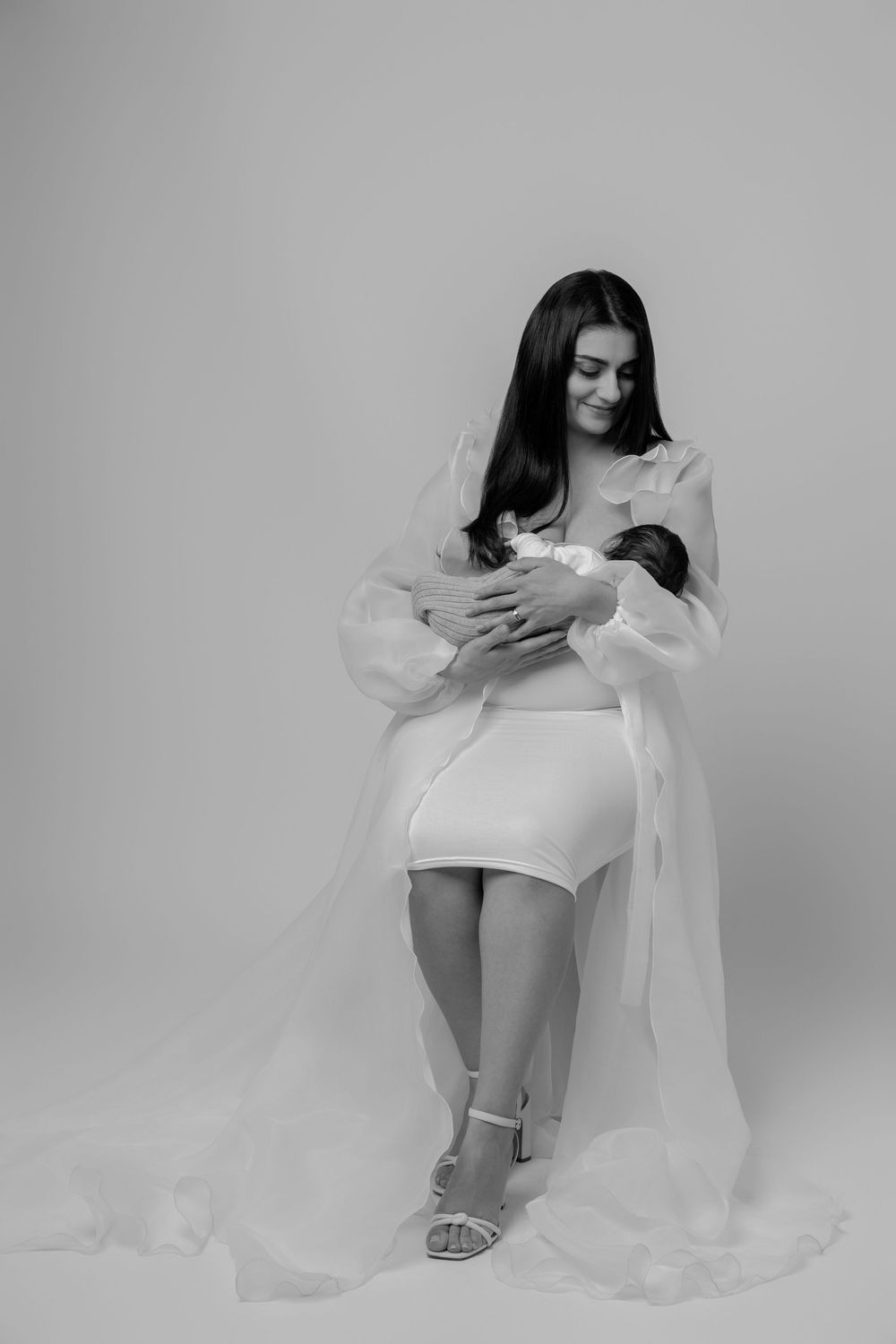 A black and white artistic photo series showing graceful poses with flowing white fabric and minimalist styling.