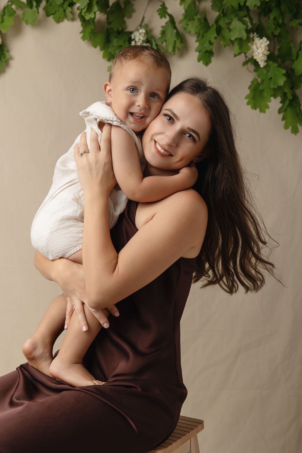 A series of tender moments captured between parent and child under green foliage against a neutral background.