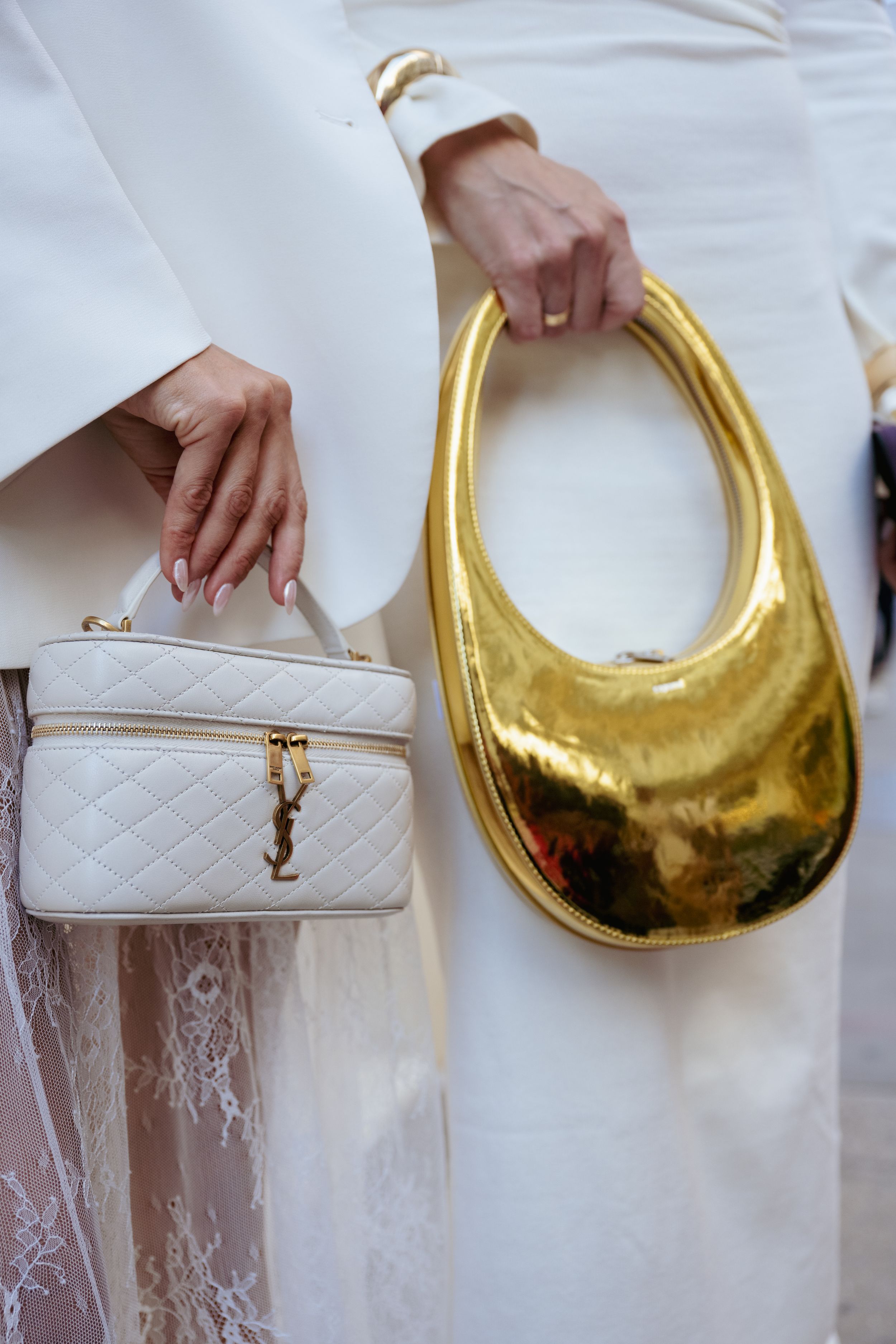 A series of fashion handbags shown side by side featuring a white quilted leather bag and a metallic gold crescent bag.