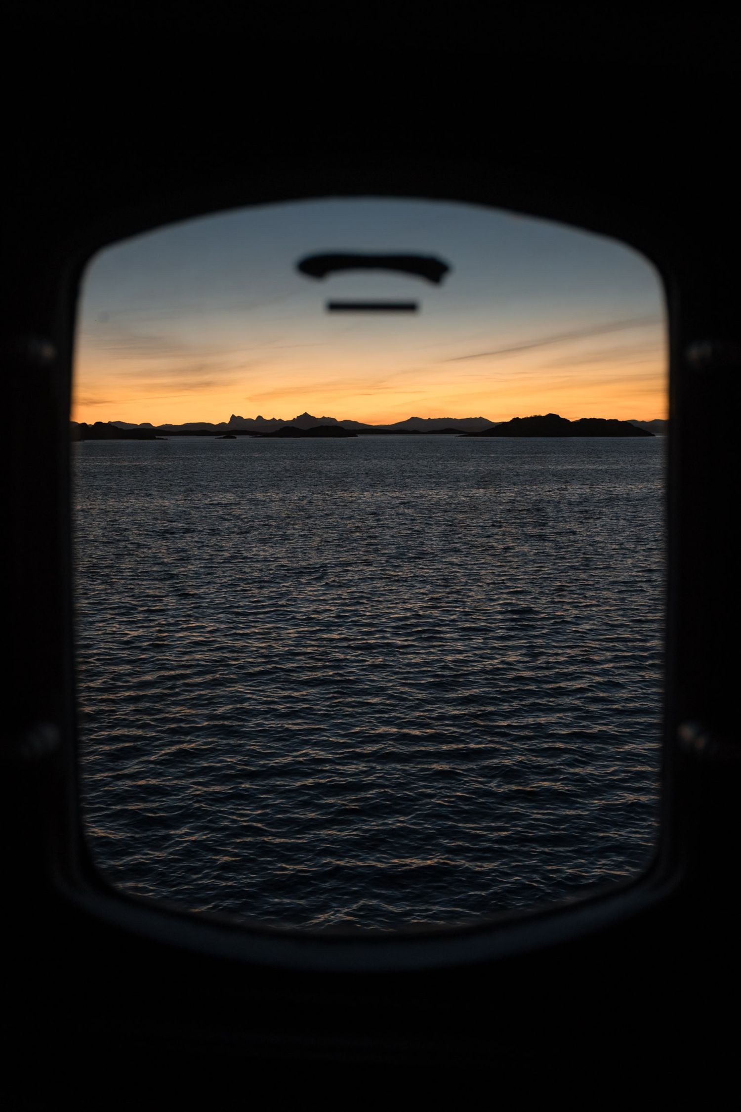 hublot du bateau avec lever du soleil