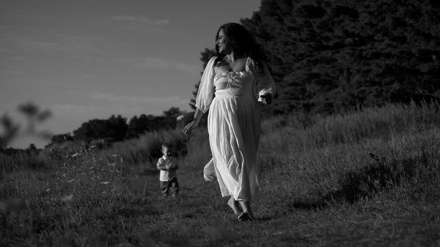 A series of black and white photos showing a person walking through a grassy hillside landscape.
