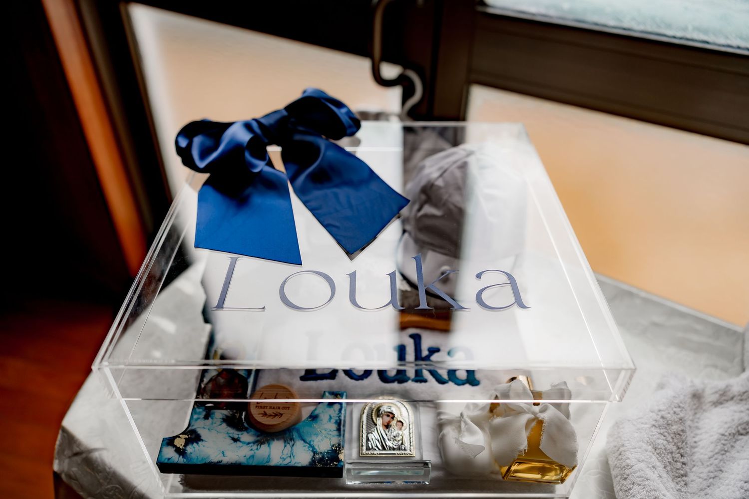 Close-up of baptism decorations featuring blue bow and personalized name display.